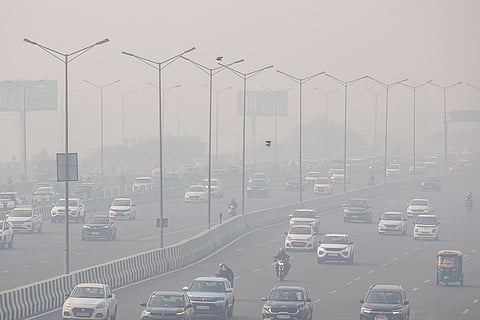 Vehicles move on a road amid low visibility due to smog, in New Delhi.