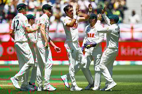 Australia's Mitchell Starc, center, celebrates with teammates the wicket of England's Ben Duckett during the first Ashes cricket test match between Australia and England in Perth.