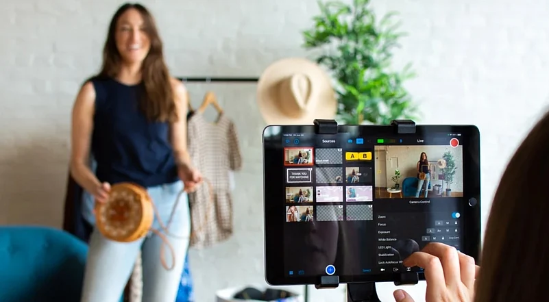 Woman modeling a round bag for a live fashion stream