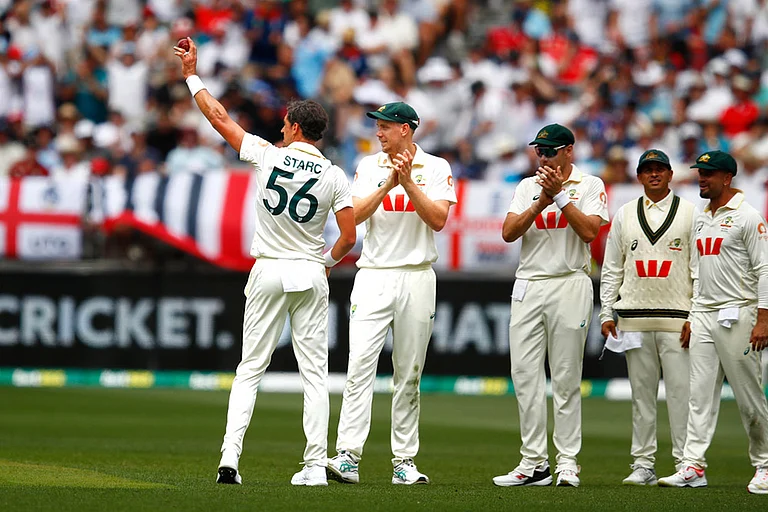 Australia's Mitchell Starc, left, lifts the ball to acknowledge his tenth wicket in the first Ashes cricket test match between Australia and England in Perth. - | Photo: AP/Gary Day