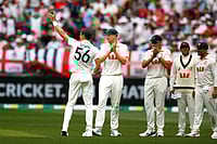 | Photo: AP/Gary Day : Australia's Mitchell Starc, left, lifts the ball to acknowledge his tenth wicket in the first Ashes cricket test match between Australia and England in Perth.