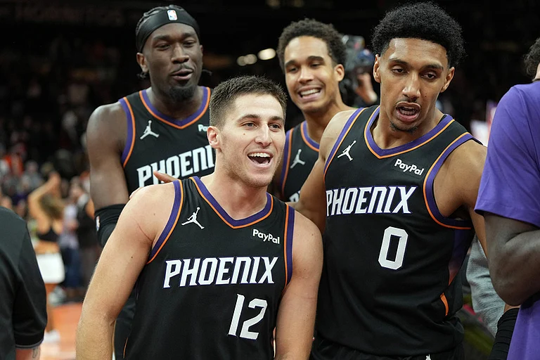 Phoenix Suns guard Collin Gillespie (12) celebrates with teammates after hitting the winning shot against the Minnesota Timberwolves during the second half of an NBA Cup basketball game, in Phoenix. - | Photo: AP/Rick Scuteri