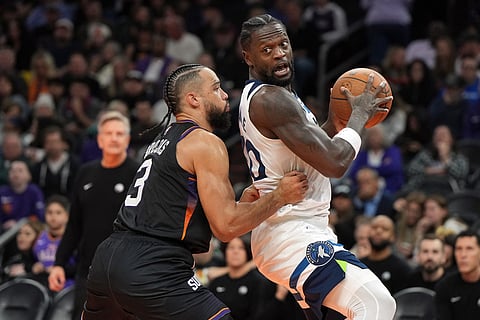 Minnesota Timberwolves forward Julius Randle (30) shields the ball from Phoenix Suns forward Dillon Brooks during the second half of an NBA Cup basketball game in Phoenix. 