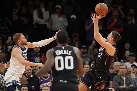 Phoenix Suns guard Collin Gillespie (12) shoots the winning shot against the Minnesota Timberwolves during the second half of an NBA Cup basketball game in Phoenix. 