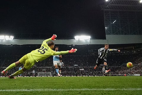 Newcastle's Harvey Barnes misses in front of Manchester City's goalkeeper Gianluigi Donnarumma during a Premier League soccer match between Newcastle United and Manchester City in Newcastle, England.