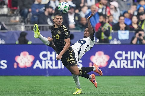 Los Angeles FC's Sergi Palencia,  left, and Vancouver Whitecaps' Ali Ahmed, right, vie for the ball during the first half of the MLS Western Conference semifinal soccer match in Vancouver, British Columbia.