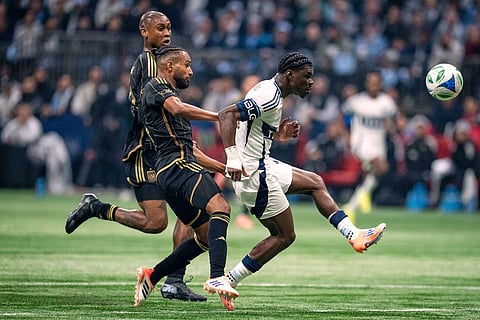 Vancouver Whitecaps' Emmanuel Sabbi, right, kicks the ball to score as Los Angeles FC's Eddie Segura, front left, and Nkosi Tafari, back, defend during the first half of the MLS Western Conference semifinal playoff soccer match, in Vancouver.