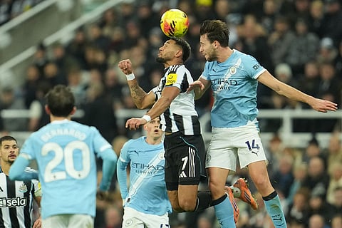 Newcastle's Joelinton, left, and Manchester City's Nico Gonzalez jump for the ball during a Premier League soccer match between Newcastle United and Manchester City in Newcastle, England.
