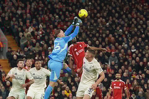 Nottingham Forest's goalkeeper Matz Sels punches the ball away under pressure from Liverpool's Alexander Isak, centre, during the English Premier League soccer match between Liverpool and Nottingham Forest in Liverpool, England.