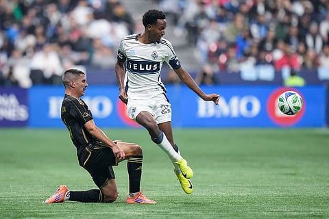 Vancouver Whitecaps' Ali Ahmed, right, passes the ball as Los Angeles FC's Sergi Palencia, left, defends during the first half of the MLS Western Conference semifinal soccer match in Vancouver, British Columbia.