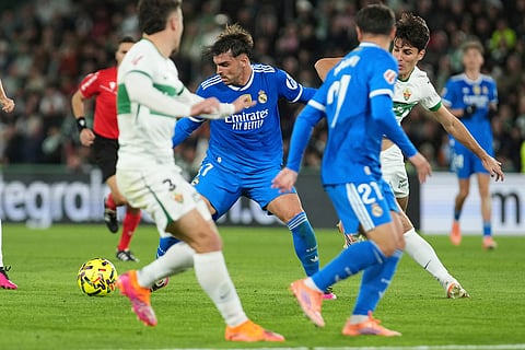 Real Madrid's Raul Asencio, centre, challenges for the ball during the Spanish La Liga soccer match between Elche and Real Madrid in Elche, Spain.