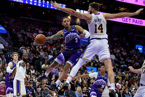 Utah Jazz guard Keyonte George (3) passes the ball around the defense of Los Angeles Lakers forward Maxi Kleber (14) during the second half of an NBA basketball game in Salt Lake City.