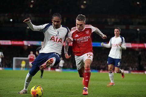 Tottenham's Djed Spence, left, and Arsenal's Leandro Trossard fight for the ball during a Premier League soccer match between Arsenal and Tottenham in London.