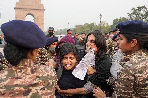 Police and security personnel remove people protesting against worsening air quality in the national capital, at the India Gate, in New Delhi.