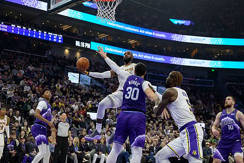 Los Angeles Lakers forward LeBron James, center top, drives to the basket while defended by Utah Jazz center Jusuf Nurkic (30) during the first half of an NBA basketball game in Salt Lake City.