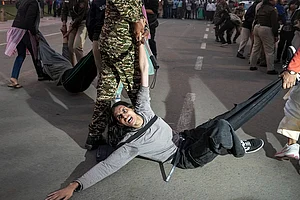 | Photo: PTI/Karma Bhutia : A protester being detained by security personnel during a protest against worsening air quality in the national capital, near the India Gate, in New Delhi. The air quality remained in the "very poor" category on Sunday morning, with the overall Air Quality Index (AQI) recorded at 381, according to the Central Pollution Control Board (CPCB).