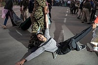 | Photo: PTI/Karma Bhutia : A protester being detained by security personnel during a protest against worsening air quality in the national capital, near the India Gate, in New Delhi. The air quality remained in the "very poor" category on Sunday morning, with the overall Air Quality Index (AQI) recorded at 381, according to the Central Pollution Control Board (CPCB). 
