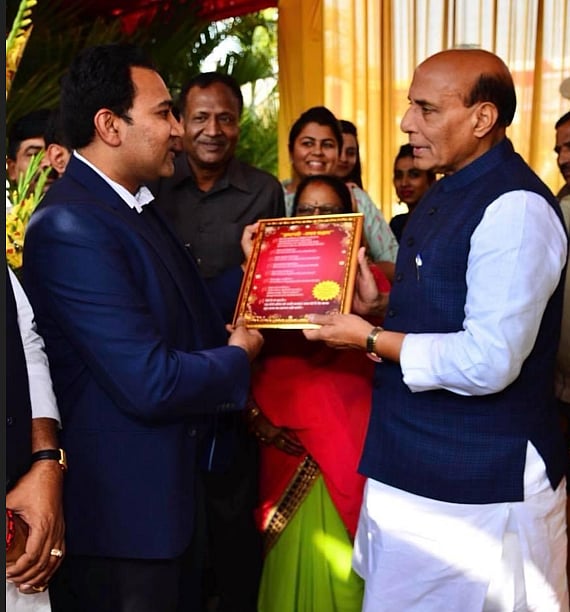 Dr. Mohit Agarwal receiving a framed award during a ceremony.