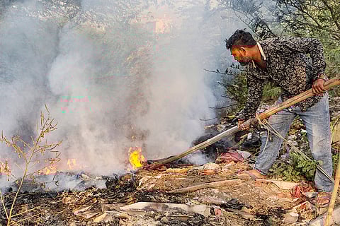 A man incinerates waste, in Gurugram.