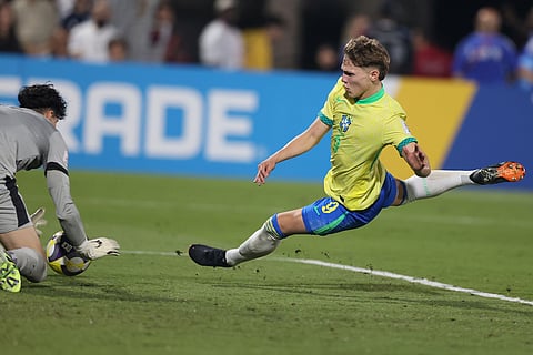 Brazil's Dell tries to beat Portugal's Romario Cunha during the FIFA U17 World Cup semifinal soccer match between Portugal and Brazil in Doha, Qatar.