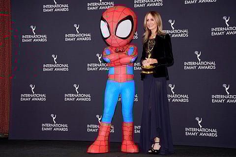 Dana Walden, co-chairman of Disney Entertainment and winner of the Founders Award, poses with a Spider-Man character in the press room during the 53rd International Emmy Awards at the New York Hilton Midtown in New York. 