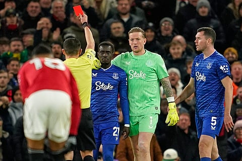 Everton's Idrissa Gueye, third right, gets a red card from referee Tony Harrington during the English Premier League soccer match between Manchester United and Everton in Manchester, England.