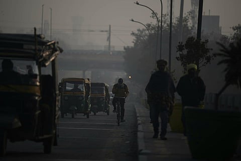 Vehicles ply on a road amid smog as air quality deteriorates, in Faridabad.