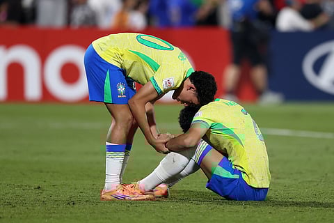 Brazilian players react after losing on penalties to Portugal during the FIFA U17 World Cup semifinal soccer match in Doha, Qatar.