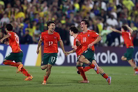 Portugal players celebrate their victory after beating Brazil in a penalty shootout during the FIFA U17 World Cup semifinal soccer match in Doha, Qatar.