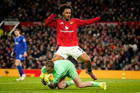 Everton's goalkeeper Jordan Pickford saves in front of Manchester United's Joshua Zirkzee during the English Premier League soccer match between Manchester United and Everton in Manchester, England.