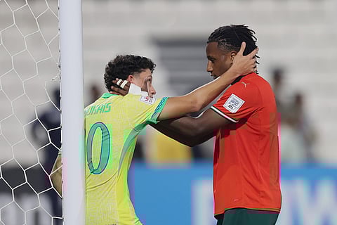Brazil's Gabriel Mec is comforted by Portugal's Mauro Furtado at the end of the FIFA U17 World Cup semifinal soccer match between Portugal and Brazil in Doha, Qatar.