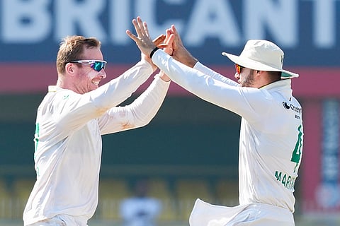 South Africa's Simon Harmer and Aiden Markram celebrate the wicket of India's captain Rishabh Pant during the fifth day of the second Test cricket match between India and South Africa, at ACA Stadium, Barsapara in Guwahati.