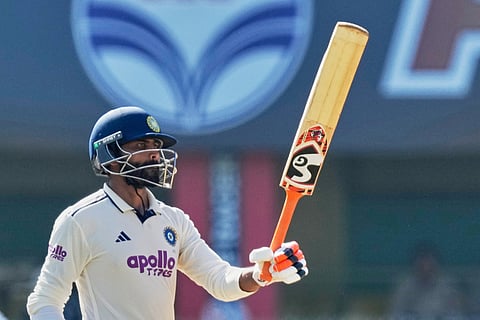 India's Ravindra Jadeja celebrates after scoring fifty runs on the fifth day of the second cricket test match between India and South Africa in Guwahati.
