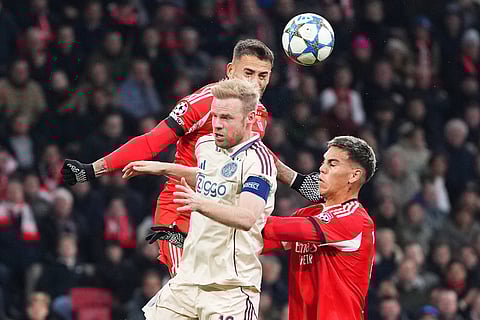Benfica's Enzo Barrenechea, right, challenges for the ball with Ajax's Davy Klaassen, centre, during the Champions League opening phase soccer match between Ajax and SL Benfica in Amsterdam, Netherlands.