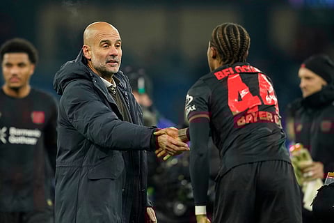 Manchester City's head coach Pep Guardiola, left shakes hands with Leverkusen's Jeanuel Belocian after the end of the Champions League opening phase soccer match between Manchester City and Bayer Leverkusen in Manchester, England.