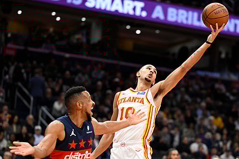 Atlanta Hawks forward Zaccharie Risacher (10) reaches for a rebound over Washington Wizards guard CJ McCollum during the first half of an NBA Cup basketball game in Washington.