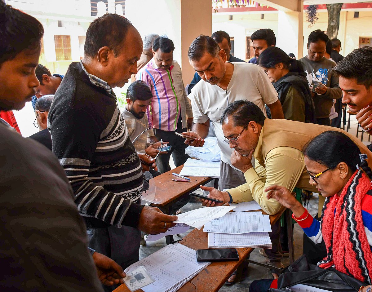 PTI Photo : Booth Level Officers check and collect enumeration forms as voters arrive to submit them for the special intensive revision (SIR) of electoral rolls, in Prayagraj, Sunday, Nov. 23, 2025.
