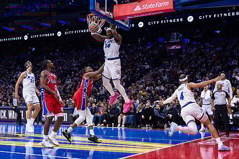 Orlando Magic's Wendell Carter Jr. (34) dunks the ball after taking the pass from Jalen Suggs (4) with Philadelphia 76ers' Jabari Walker, center left, defending during the first half of an NBA Cup basketball game in Philadelphia. 