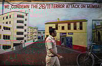 Kunal Patil : A police constable walks past a mural depicting Nariman House, one of the sites of the 2008 Mumbai terror attacks, on the eve of the anniversary of the gruesome incident, in Mumbai. 