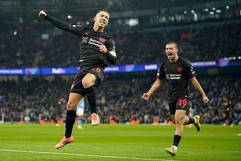 Leverkusen's Alex Grimaldo celebrates after scoring the opening goal of the game during the Champions League opening phase soccer match between Manchester City and Bayer Leverkusen in Manchester, England.