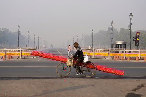 A cyclist at the Kartavya Path on a cold and smoggy winter morning, as air quality remains poor in the national capital, in New Delhi.