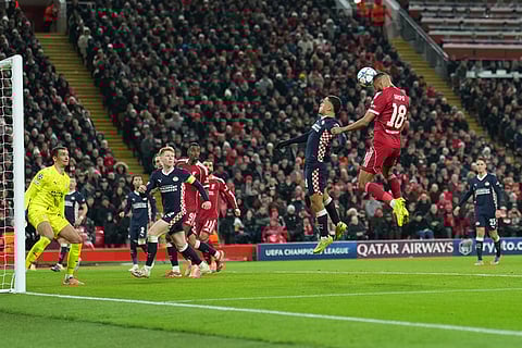 Liverpool's Cody Gakpo, right, heads the ball during the Champions League opening phase soccer match between Liverpool and PSV in Liverpool, England.