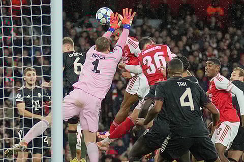 Arsenal's Jurrien Timber, top center, scores the opening goal during the Champions League opening phase soccer match between Arsenal and Bayern Munich in London.
