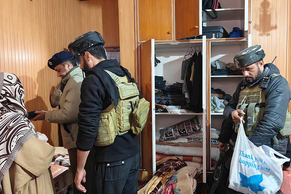 Police with CRPF personnel carry out a search at the residence of a person linked to banned Jamaat-e-Islami, in Pulwama. J&K Police carried out raids at multiple locations across the Kashmir Valley as part of its crackdown on the banned Jamaat-e-Islami (JeI), officials said.  - | Photo: PTI 