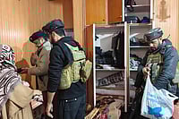 Day In Pics: November 27, 2025 | Photo: PTI : Police with CRPF personnel carry out a search at the residence of a person linked to banned Jamaat-e-Islami, in Pulwama. J&K Police carried out raids at multiple locations across the Kashmir Valley as part of its crackdown on the banned Jamaat-e-Islami (JeI), officials said.