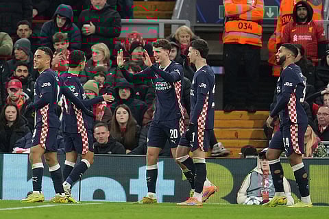 PSV's Guus Til, centre, celebrates with teammates after scoring his side's second goal during the Champions League opening phase soccer match between Liverpool and PSV in Liverpool, England.