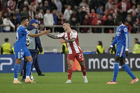 Olympiacos' Gabriel Strefezza, right, and Real Madrid's Kylian Mbappe at the end of the Champions League opening phase soccer match between Olympiacos and Real Madrid, in Piraeus port, near Athens, Greece.