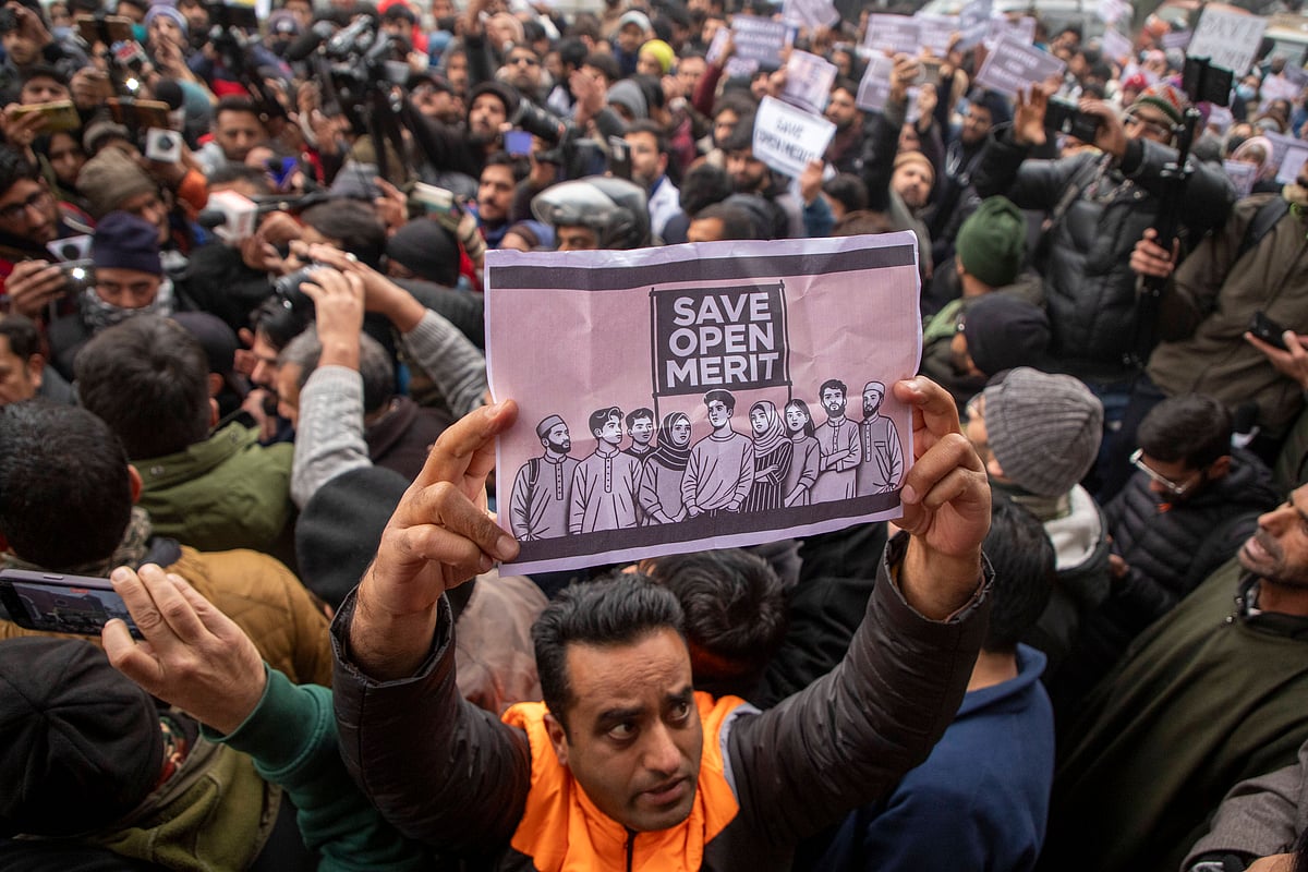 A Kashmiri man holds a placard during a protest outside the chief minister’s official residence in Srinagar against Jammu and Kashmir’s reservation policy. - ZUMA Wire