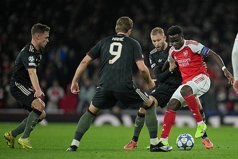 Arsenal's Bukayo Saka, right, is closed down by Bayern's Joshua Kimmich, Harry Kane and Konrad Laimer, from left, during the Champions League opening phase soccer match between Arsenal and Bayern Munich in London.