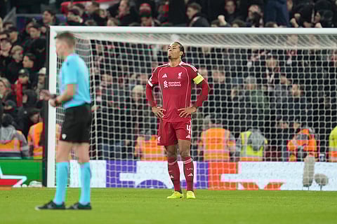 Liverpool's Virgil van Dijk reacts after PSV's Couhaib Driouech scored his side's fourth goal during the Champions League opening phase soccer match between Liverpool and PSV in Liverpool, England.